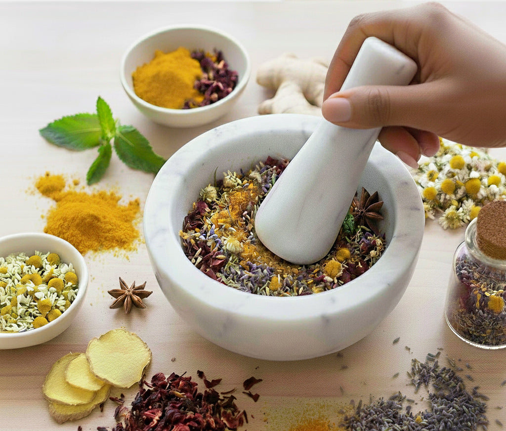 Marble mortar and pestle with dried herbs, turmeric, chamomile, lavender, and ginger for blending functional wellness tea