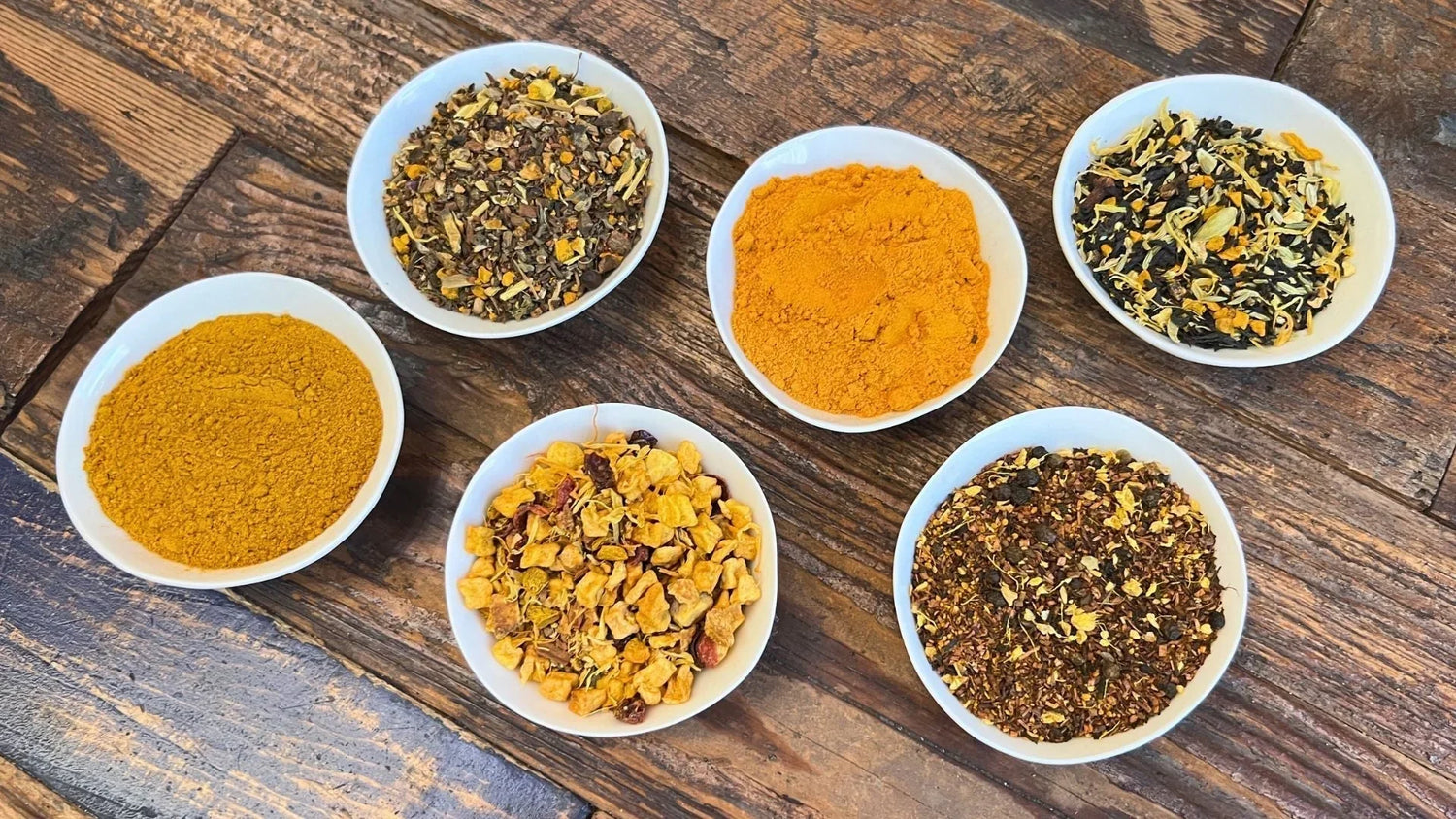 Therapeutic turmeric powder and herbal tea blends in white bowls — anti-inflammatory turmeric collection from Tea & Turmeric Laguna Beach Orange County
