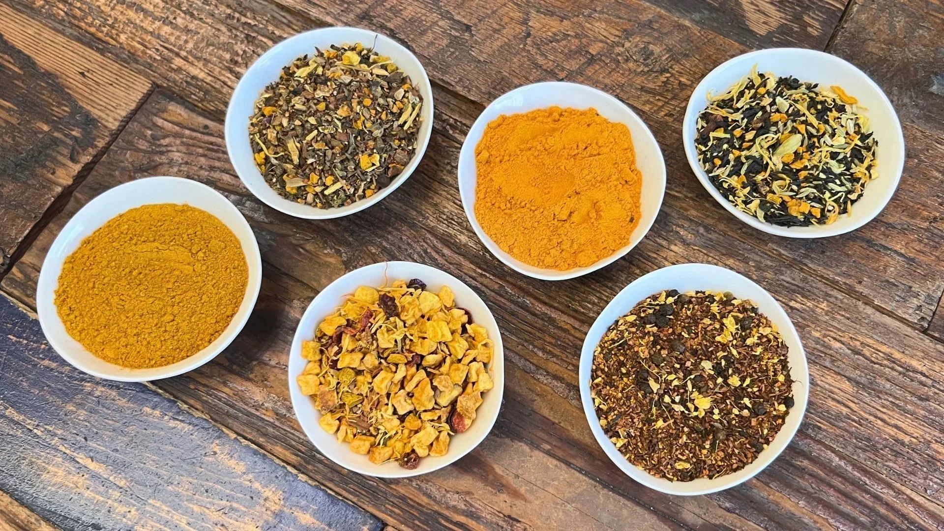 Therapeutic turmeric powder and herbal tea blends in white bowls — anti-inflammatory turmeric collection from Tea & Turmeric Laguna Beach Orange County